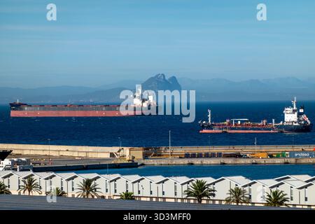 Ceuta, Spagna - 24 ottobre 2025: Navi che navigano nello stretto di Gibilterra viste da Ceuta, una città spagnola del Nord Africa, con la Rocca di Gibilterra Foto Stock
