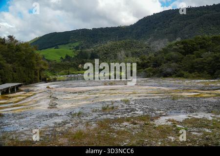Il parco geotermico Orakei Korako, nuova Zelanda, offre vivaci terrazze minerali, terreno fumante, sorgenti termali calde e una passerella. Colline lussureggianti e acqua potabile Foto Stock