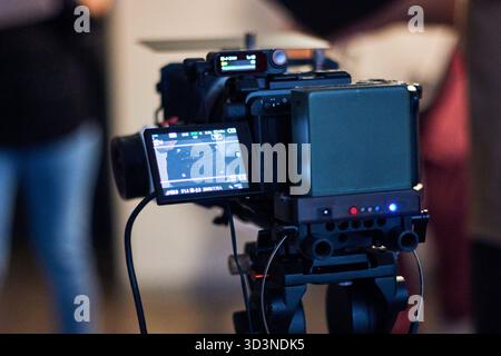 Dietro le quinte di una produzione audiovisiva, registrando film e monitorandoli attraverso schermi e telecamere. Del direttore e del team di produzione Foto Stock