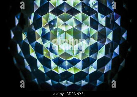 Affascinante sfondo caleidoscopio astratto con motivo geometrico di luce verde e blu. Questo ipnotico mosaico di cristallo simmetrico crea un'atmosfera da favola Foto Stock