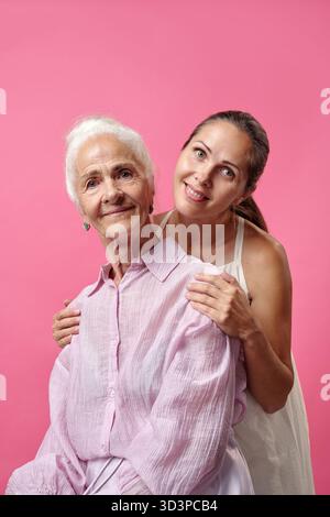 Donna caucasica anziana seduta con giovane donna caucasica adulta sorridente Foto Stock