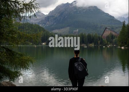 Vista sul retro di una donna che si affaccia sul lago di montagna Foto Stock