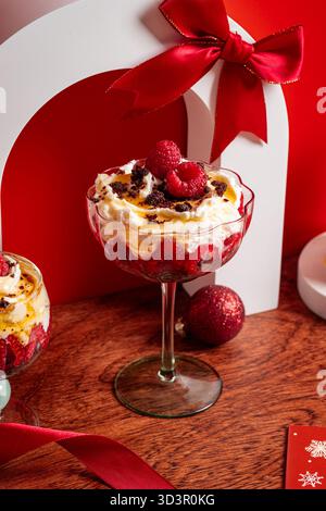 Dolce natalizio con brownie di cioccolato, lamponi freschi e panna vellutata, splendidamente guarniti per un drink Foto Stock