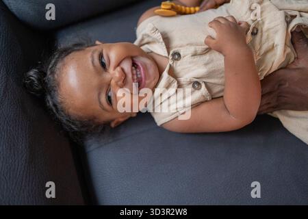 Una madre e una figlia afroamericana gioiose condividono momenti preziosi a casa. Il bambino sorridente si diverte a divertirsi insieme, catturando l'essenza di Foto Stock