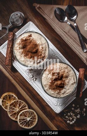 Un budino di riso cremoso fatto in casa, guarnito con fragranti fette di cannella e limone. Un delizioso dessert che offre un sapore caldo e confortante di trad Foto Stock