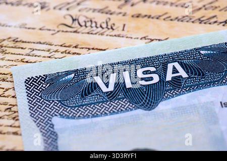 Vista ravvicinata di un visto per gli Stati Uniti stampigliato su una pagina del passaporto con sfondo della Costituzione degli Stati Uniti. Concetto di viaggio e immigrazione Foto Stock