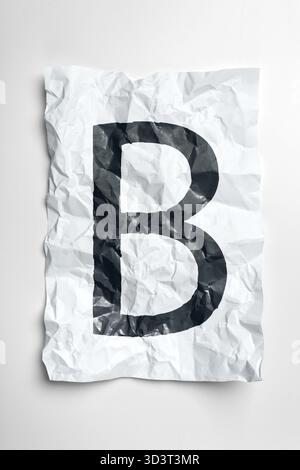 Carta arricciata con lettera B nera grande su sfondo normale Foto Stock