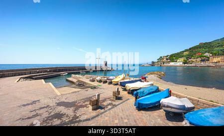 Barche sul lungomare, il piccolo faro e la spiaggia di Recco in estate. Provincia di Genova, regione Liguria, Italia Foto Stock