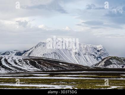 Montagne colorate Landmannalaugar sotto la neve in autunno, Islanda. Campi di lava di sabbia vulcanica in primo piano. Foto Stock
