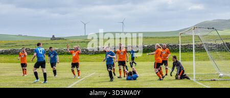 La squadra di calcio amatoriale dei Papay gioca contro Sanday nella Orkney Amateur Football Association League (Orcadian Parish Cup), Pierowall, Westray, Scozia, Regno Unito Foto Stock