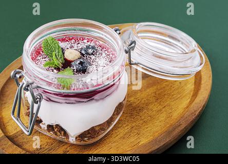 Cibo, Granola con noci, yogurt e frutti di bosco in un barattolo Foto Stock