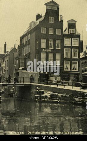 Questa cartolina del 1939 di una serie mostra Delftsevaart al Westewagenstraat di Rotterdam. Cattura il lungomare della città e l'ambiente urbano circostante durante la fine degli anni '1930, un periodo di sviluppo e modernizzazione. Foto Stock