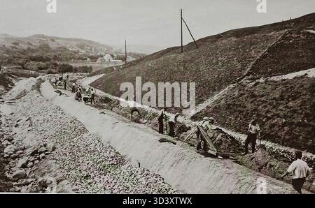 Una fotografia del 1937 che mostra la costruzione dell'autostrada Emaiiai vicino ad Ariogala, in Lituania. L'immagine cattura lavoratori e macchinari impegnati nel lavoro stradale durante lo sviluppo dell'autostrada. Foto Stock