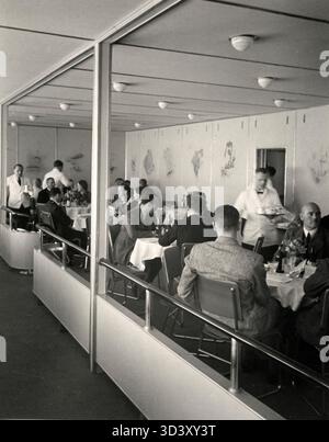 Nel 1936, il dirigibile L.Z.129 Hindenburg fu completato presso il cantiere navale di Friedrichshafen in Germania. L'Hindenburg, riempito di idrogeno, era più grande e più esplosivo del Graf Zeppelin. Questa foto mostra i passeggeri che sorseggiano bevande nella confortevole lounge del dirigibile durante il suo primo volo per il Sud America. Foto Stock