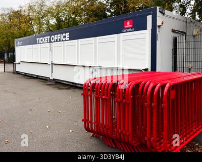 Manchester, Regno Unito - 30 settembre 2025: Biglietteria con persiane bianche e barriere rosse luminose in uno stadio di Manchester. Foto Stock