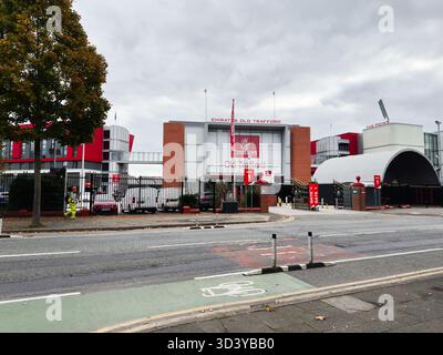 Manchester, Regno Unito - 30 settembre 2025: Ingresso all'Old Trafford Stadium di Manchester, con cancelli, automobili e un cielo nuvoloso. Foto Stock