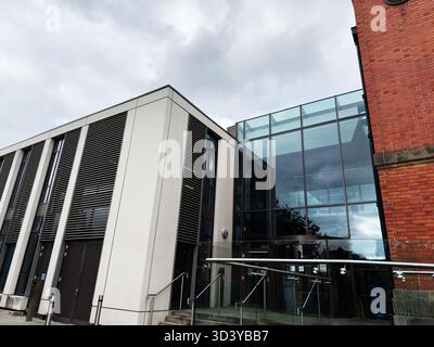 Manchester, Regno Unito - 30 settembre 2025: Moderno edificio di Manchester con facciata in vetro, mattoni e ringhiere in metallo. Foto Stock