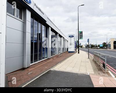 Manchester, Regno Unito - 30 settembre 2025: Negozio Ford lungo una strada cittadina con pannelli di vetro e dintorni urbani. Foto Stock
