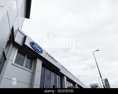 Manchester, Regno Unito - 30 settembre 2025: Vista esterna di un negozio Ford a Manchester, caratterizzato da pannelli eleganti e grandi finestre. Foto Stock