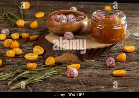 marmellata d'arancia composta da arance e agrumi ed essiccata in sciroppo di zucchero, frutta kumquat intera in polvere bianca, un vaso di vetro con marmellata d'arancia è sulla t Foto Stock