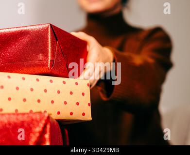Scatole regalo in mano a una donna. Donna che prepara la sorpresa. Foto Stock