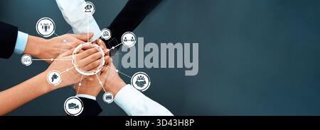 Questa immagine mostra un gruppo eterogeneo di professionisti che si riuniscono in un ambiente di business dinamico, simboleggiando l'unità attraverso il lavoro di squadra e. Foto Stock