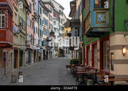 Colorati edifici storici e finestre a bovindo fiancheggiano la pittoresca Augustinergasse nella città Vecchia di Zurigo, Canton di Zurigo Foto Stock