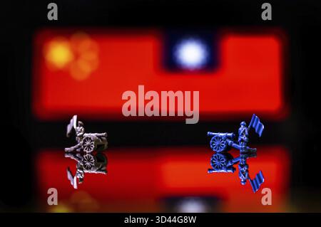 Immagine concettuale della guerra tra Cina e Taiwan utilizzando soldati giocattolo e bandiere nazionali su sfondo riflettente Foto Stock