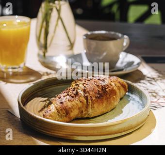 Cibo, tazza di caffè caldo fresco, succo d'arancia e tradizionale croissant francese sul tavolo del caffè parigino all'aperto a parigi Foto Stock