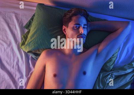 Ritratto di un giovane su un letto dall'alto Foto Stock