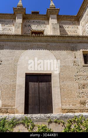 Moresco arco islamico al di sopra di una porta di legno in Granada, Spagna, Europa in una luminosa giornata di sole Foto Stock
