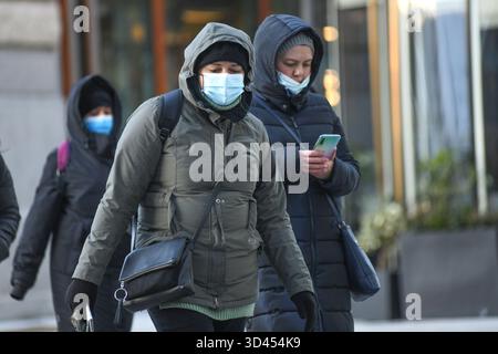 Persone che indossano maschere per la strada durante l'inverno a Budapest, Ungheria Foto Stock