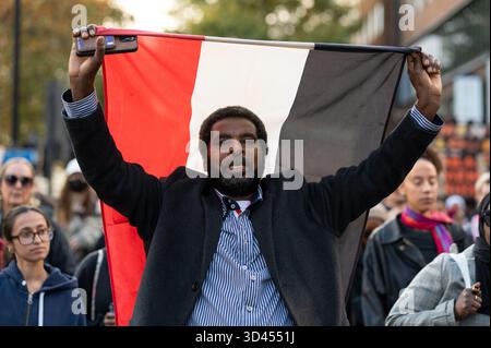 Londra, Regno Unito. 8 novembre 2025. Un uomo tiene una bandiera sudanese mentre marcia durante la manifestazione. I manifestanti hanno marciato a Londra per dimostrare solidarietà al popolo sudanese e chiedere la fine delle vendite di armi del Regno Unito agli Emirati Arabi Uniti, cosa che secondo gli attivisti gli attivisti consentono atrocità da parte della milizia RSF in tutto il paese. Credito: SOPA Images Limited/Alamy Live News Foto Stock