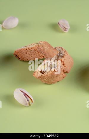 Cantucci tradizionali italiani con pezzi di pistacchio visibili, disposti ad arte su uno sfondo verde chiaro, ideali per i dessert Foto Stock