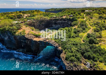 Splendido paesaggio costiero caratterizzato da un grande arco naturale sul mare a Bali Foto Stock