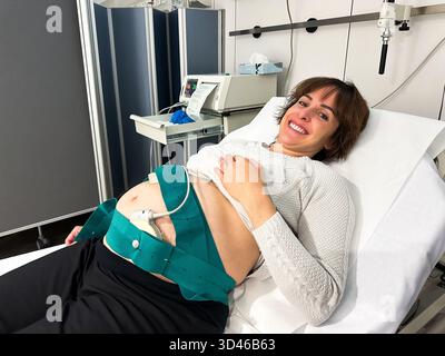 Donna incinta che ha cardiotocografia che monitora il battito cardiaco fetale durante l'esame medico Foto Stock
