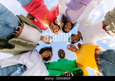 Gruppo felice di diverse giovani donne che si formano in cerchio all'aperto Foto Stock