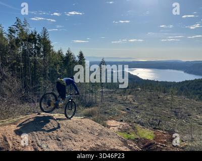 Un mountain bike su un sentiero roccioso all'Altopiano Proibita che si affaccia sul Lago Comox nella Comox Valley sull'Isola di Vancouver, Columbia Britannica, Canada. Foto Stock