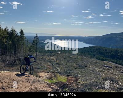 Un mountain bike su un sentiero roccioso all'Altopiano Proibita che si affaccia sul Lago Comox nella Comox Valley sull'Isola di Vancouver, Columbia Britannica, Canada. Foto Stock