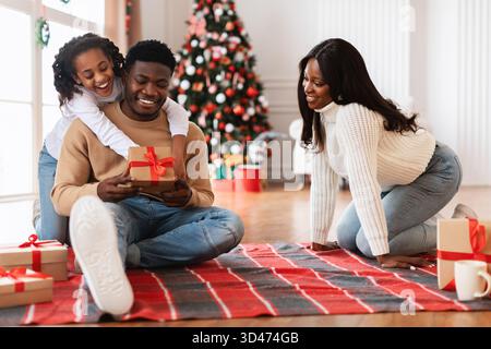 Gioia della famiglia durante le feste di Natale con scambio di regali e celebrazioni a casa Foto Stock
