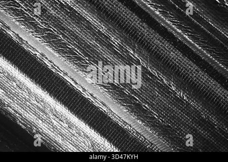 Moderno sfondo astratto con un elegante motivo a strisce diagonali. Questo dettaglio macro in bianco e nero mostra una trama in tessuto industriale, creando sophistica Foto Stock