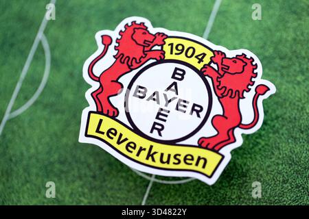 KIEV, UCRAINA - 23 FEBBRAIO 2025 il distintivo della squadra di calcio Bayer 04 Leverkusen si trova sullo sfondo del campo di calcio Foto Stock