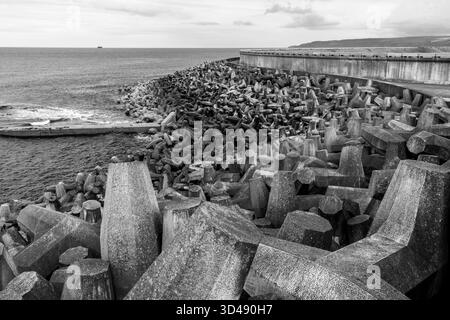 Difese marittime in cemento e frangiflutti in bianco e nero Foto Stock