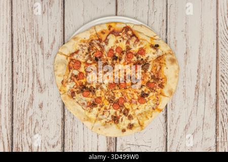 Il contrasto tra il salame, leggermente arricciato dal calore, e la salsa di pomodoro liscia crea una consistenza visivamente irresistibile e caratteristica. Foto Stock