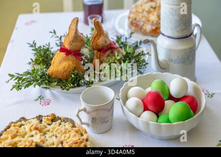 Tavola delle vacanze di Pasqua che presenta pane dolce di coniglio, uova colorate e torta con semi di papavero a Kourim Foto Stock