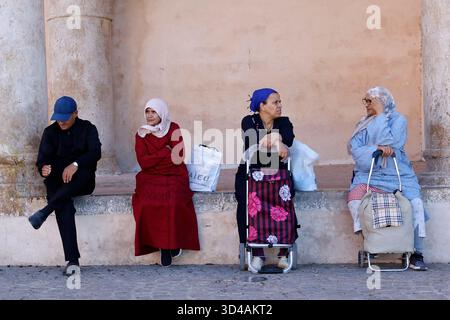Gente del posto seduta all'ombra a Meknes, in Marocco Foto Stock