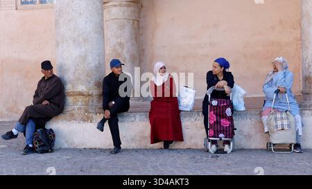 Gente del posto seduta all'ombra a Meknes, in Marocco Foto Stock