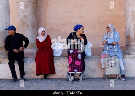 Gente del posto seduta all'ombra a Meknes, in Marocco Foto Stock