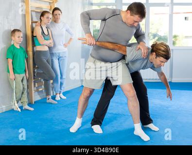 L'uomo in palestra esegue elementi di base del sistema di autodifesa krav maga. Foto Stock