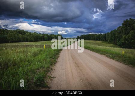 Strada della polvere tra i prati della regione della Masuria in Polonia Foto Stock